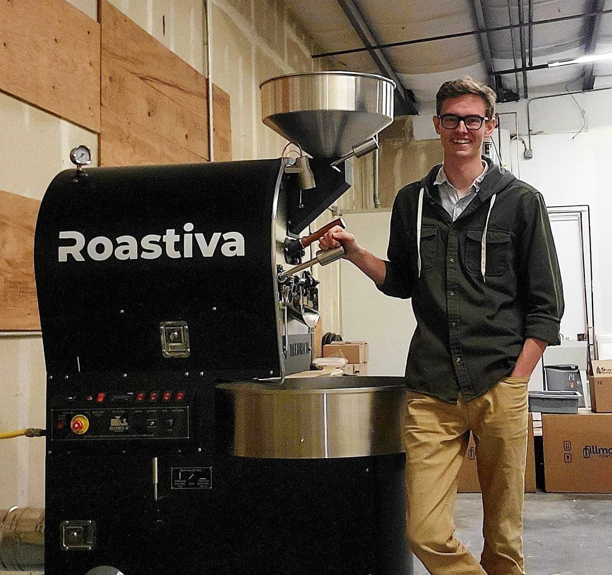 Josiah Abshear standing beside a coffee roaster